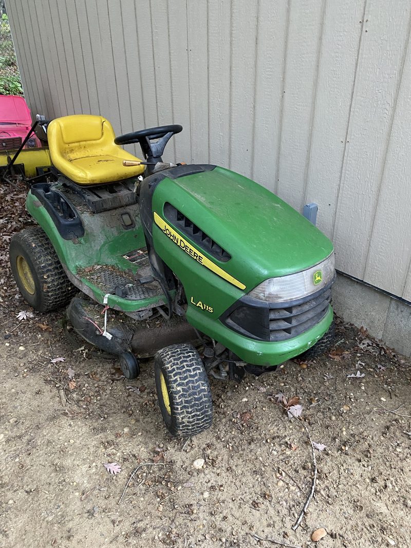 Weathered John Deere LA115 mower.